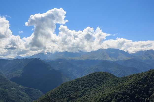 Panoramasicht auf Bergszenen im Nationalpark Dombay, Kaukasus, Russland, Europa. Dramatischer blauer Himmel und sonnige Sommerlandschaft