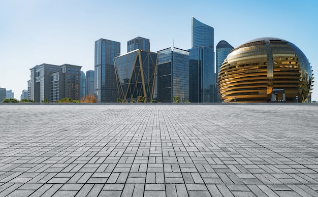 Panorámica del horizonte y edificios con piso cuadrado de concreto vacío.