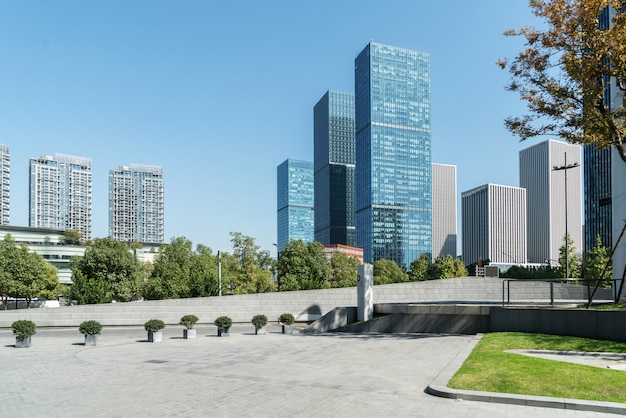 Panorámica del horizonte y edificios con piso cuadrado de concreto vacío.