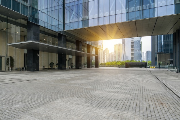 Panorámica del horizonte y edificios con piso cuadrado de concreto vacío.