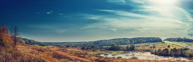 Panoramische Herbstlandschaft mit Wald, Hügeln und Straße