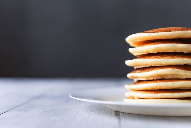 Panqueca clássica fresca empilhada em uma superfície cinza com lugar para texto