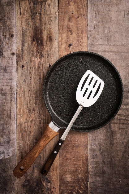 Panqueca grande plana e fundo de madeira de espátula de aço de cozinha com espaço de cópia