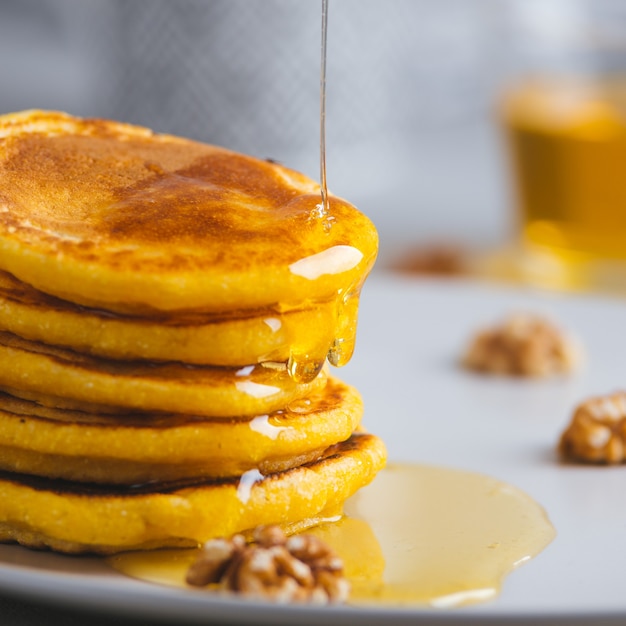 Panquecas amarelas com farinha de milho e cúrcuma, mel temperado e uvas vermelhas