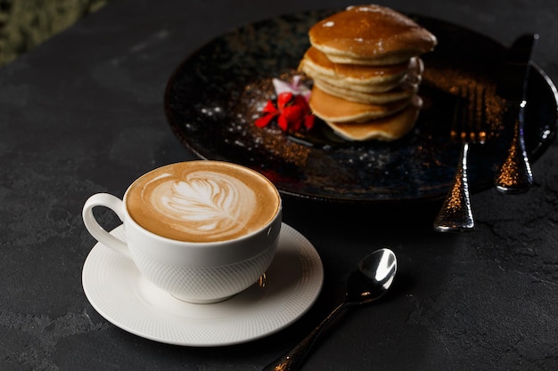 Panquecas americanas com frutas e xarope de bordo na chapa preta isolada com menu de café café