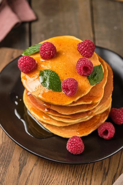 Panquecas aromatizadas com mel e framboesas frescas no café da manhã