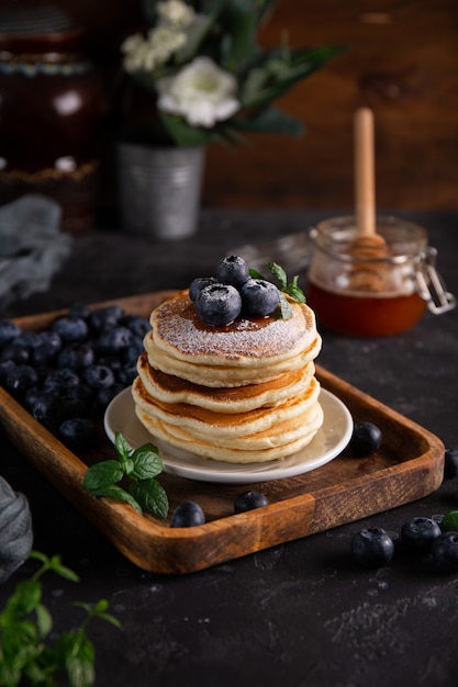 Panquecas caseiras com mirtilos e açúcar de confeiteiro em close-up da mesa.