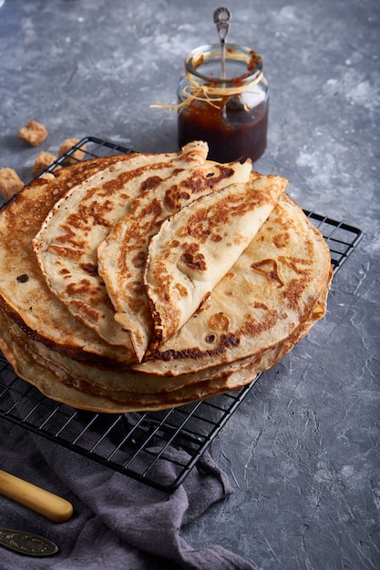 Panquecas caseiras tradicionais com geléia de baga serviram na vista superior da mesa de pedra cinza.