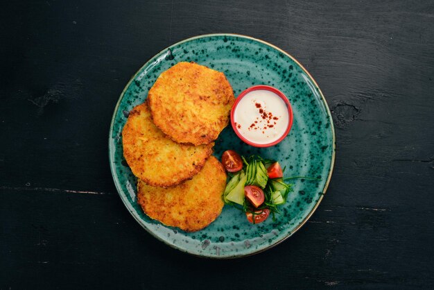 Panquecas com batatas com creme de leite Panquecas de batata Cozinha tradicional ucraniana Em uma mesa de madeira Vista superior Copiar espaço