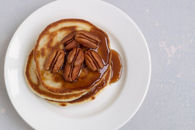 Foto panquecas com calda de caramelo e nozes.