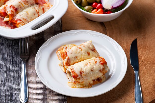 Panquecas com carne, ao molho de tomate e queijo