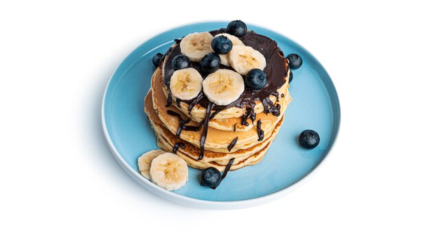 Panquecas com frutas e chocolate isoladas em branco.