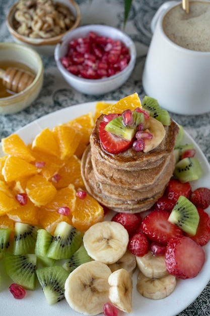 Panquecas com frutas frescas. Salada de frutas com panquecas sem glúten. Café da manhã saudável cheio de vitaminas