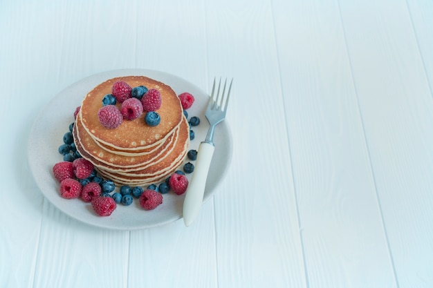 Panquecas com frutas frescas, sobre um fundo claro. Panquecas com frutas. Pequeno-almoço americano tradicional. Prato caseiro. Copie o espaço. O equilíbrio de uma alimentação saudável.