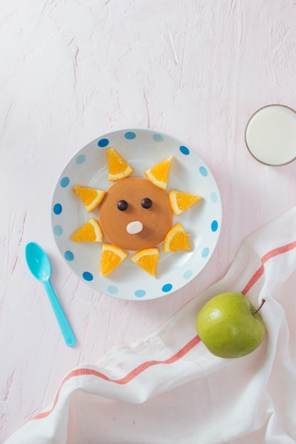 Foto panquecas com frutas para as crianças. vista do topo