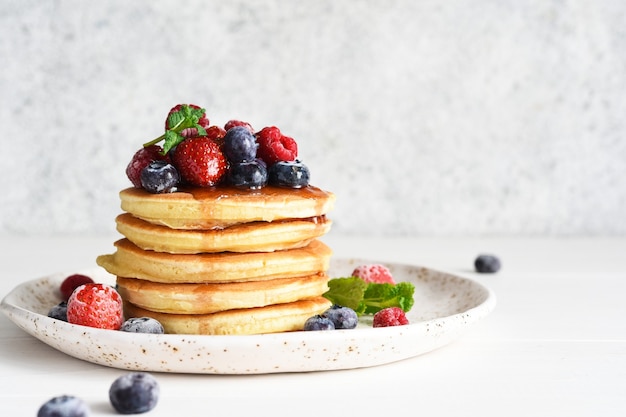 Panquecas com frutas vermelhas e xarope de bordo no café da manhã