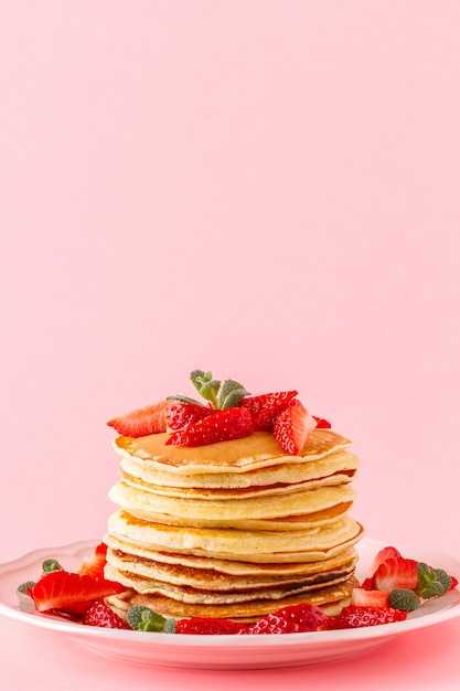 Panquecas com frutas vermelhas em um fundo pastel brilhante