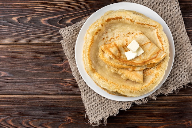 Panquecas com manteiga isoladas em branco