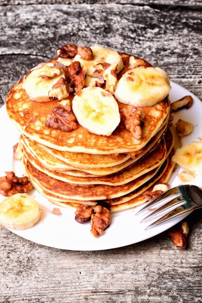 Panquecas com noz de banana em fundo de madeira