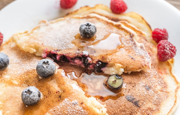 Foto panquecas com xarope de bordo e frutas vermelhas frescas