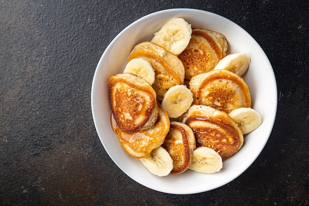 Panquecas com xarope de fatias de banana ou mel delicioso café da manhã doce sobremesa porção fresca pronta para comer