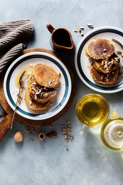 Panquecas de abóbora com nozes e xarope de bordo em uma mesa com menu de outono de chá verde