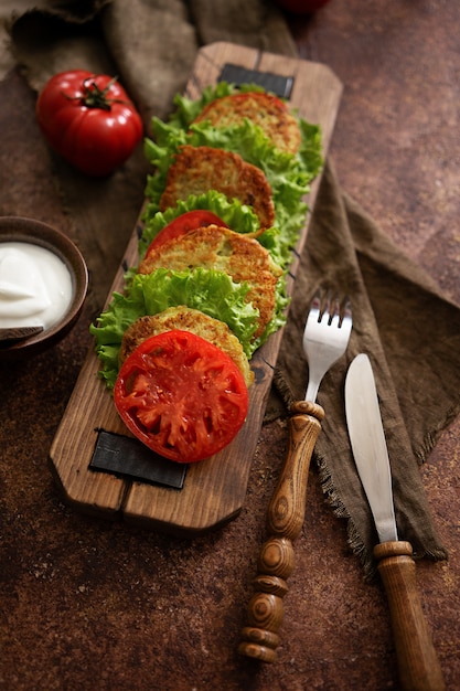 Panquecas de abobrinha com salada verde, tomate fresco e creme azedo