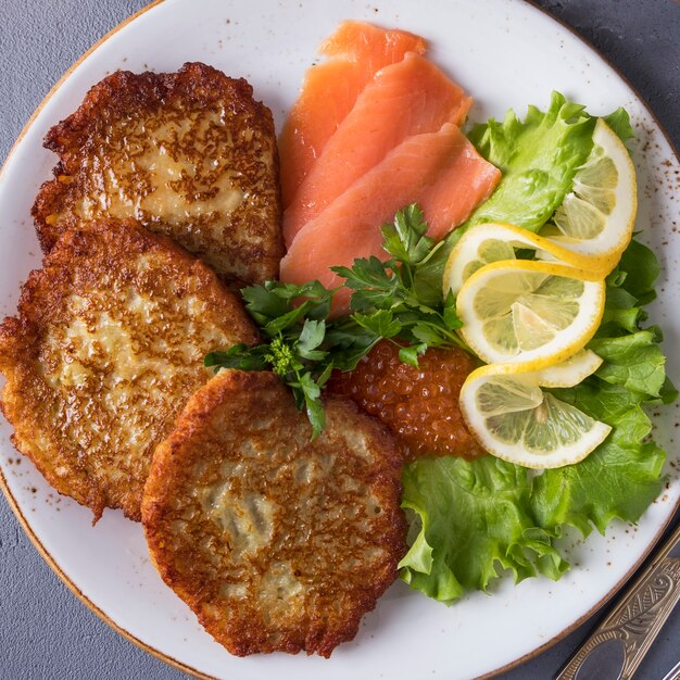 Foto panquecas de batata com caviar e salmão.