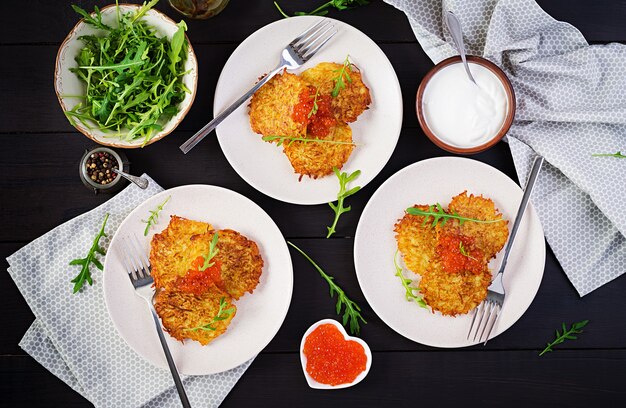 Panquecas de batata frita com caviar vermelho e creme de leite, bolinhos fritos, roesti