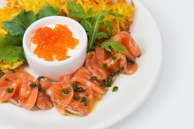 Panquecas de batata, salmão, peixe e caviar vermelho