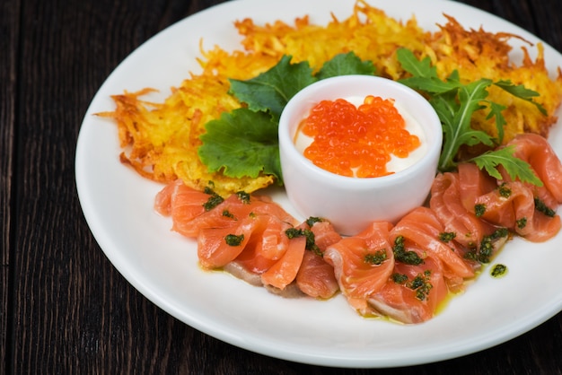 Panquecas de batata, salmão, peixe e caviar vermelho