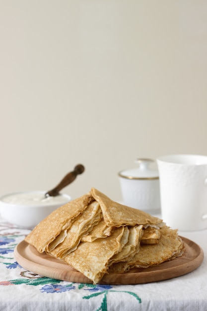 Panquecas de café da manhã servidas com creme de leite e mel.