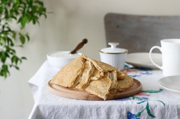 Panquecas de café da manhã servidas com creme de leite e mel.