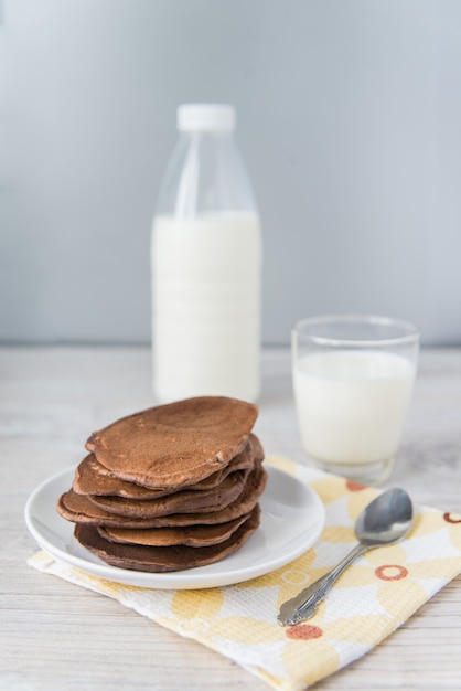 Panquecas de chocolate com copo e garrafa de leite