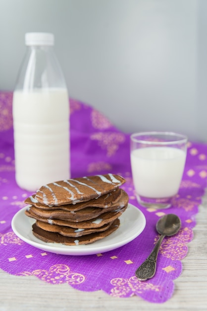 Panquecas de chocolate com copo e garrafa de leite