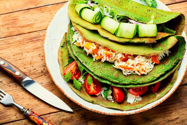 Panquecas de espinafre verdes recheadas com arroz e legumes.