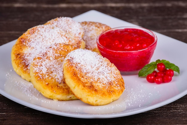 Foto panquecas de queijo com geleia de bagas em prato branco