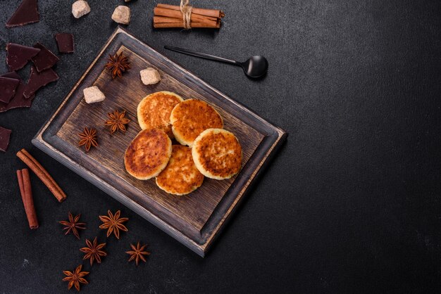 Panquecas de queijo cottage bolinhos de ricota syrniki em uma tábua de madeira Pastelaria útil caseira