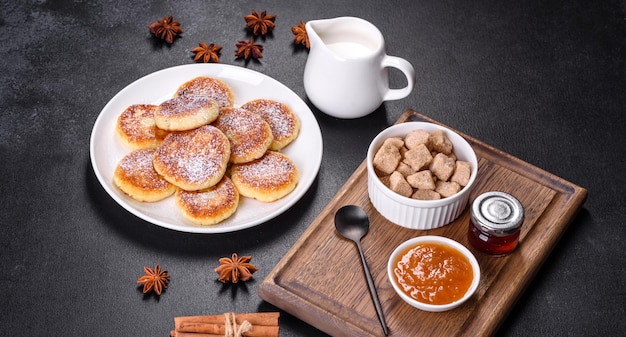 Panquecas de queijo cottage com aveia syrniki em um fundo preto rústico