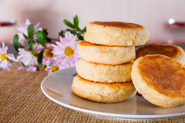 Panquecas de queijo cottage com creme de leite e geleia em um fundo marrom