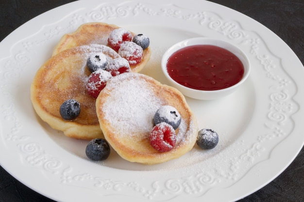 Panquecas de queijo cottage, syrniki com frutas frescas.