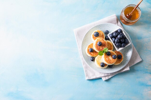 Panquecas de requeijão Cheesecakes de requeijão delicioso Café da manhã panquecas doces tradicionais russas Com hortelã e mel de mirtilo