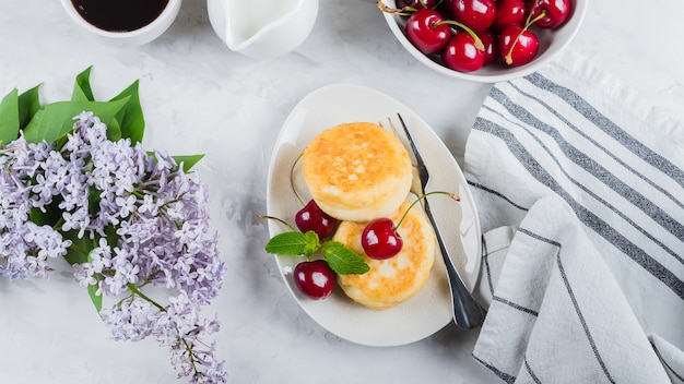 Panquecas de requeijão com cereja berry, xícara de café preto