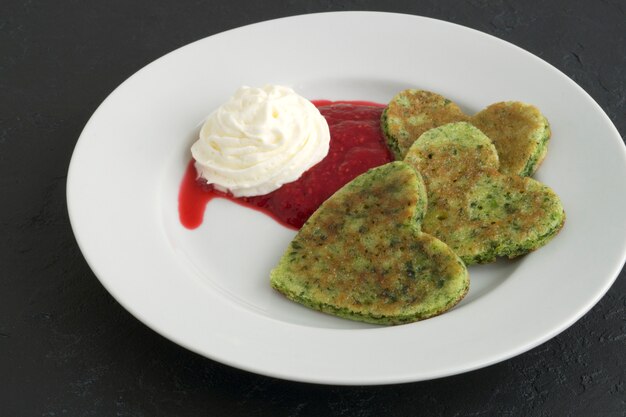 Panquecas de vegetariano verde em forma de um coração.