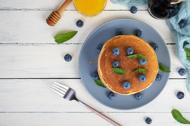 Foto panquecas deliciosas com mirtilos e mel panquecas doces com bagas frescas