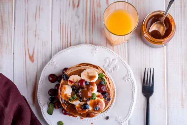 Panquecas deliciosas e exuberantes com frutas e bagas frescas, servidas com caramelo salgado.