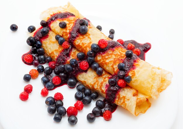 Panquecas douradas com molho de frutas vermelhas com mirtilos e morangos silvestres