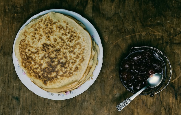 Panquecas e geléia em fundo de madeira velho