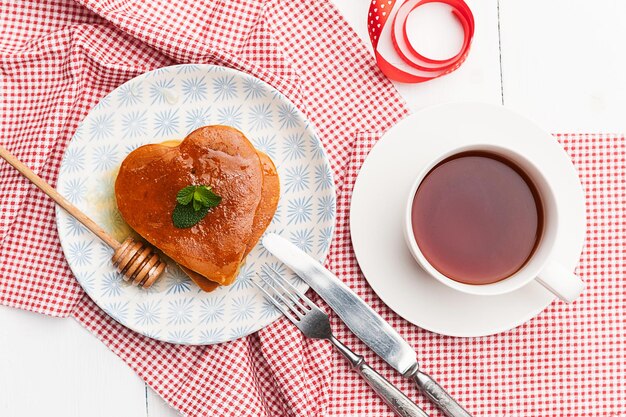 panquecas em forma de coração sobre um fundo claro o conceito de um café da manhã festivo para o Dia dos Namorados ou uma agradável surpresa para um ente querido