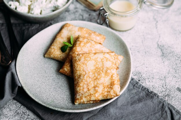 Panquecas finas com ervas, salmão e cream cheese em um prato